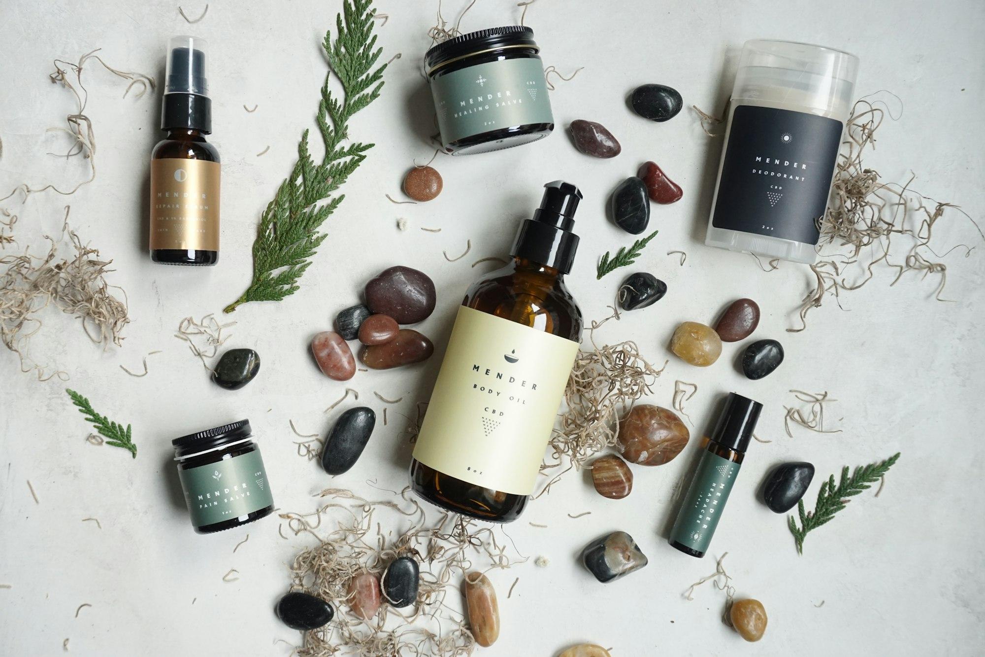 Skincare bottles and jars styled with stones and greenery